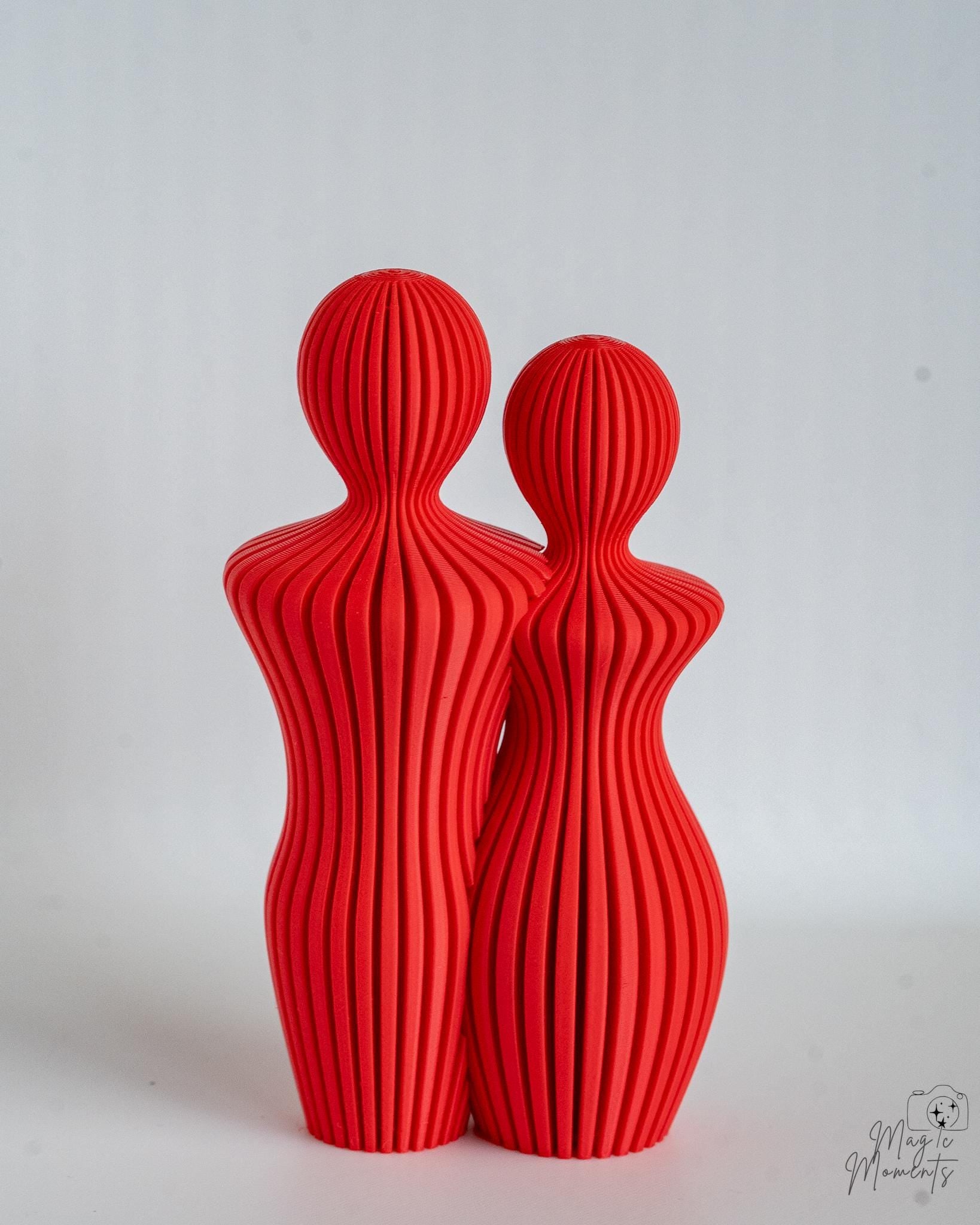 Red abstract couple sculpture pair with ribbed texture detail
