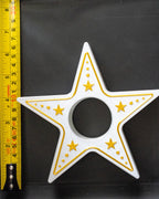 Star-shaped tealight holder with gold accents on a black background, measured by a yellow ruler.