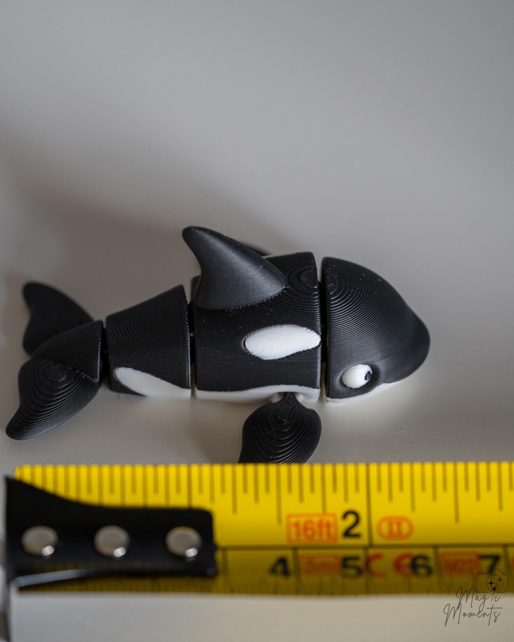 orca killer whale figurine with a measuring tape for scale 
