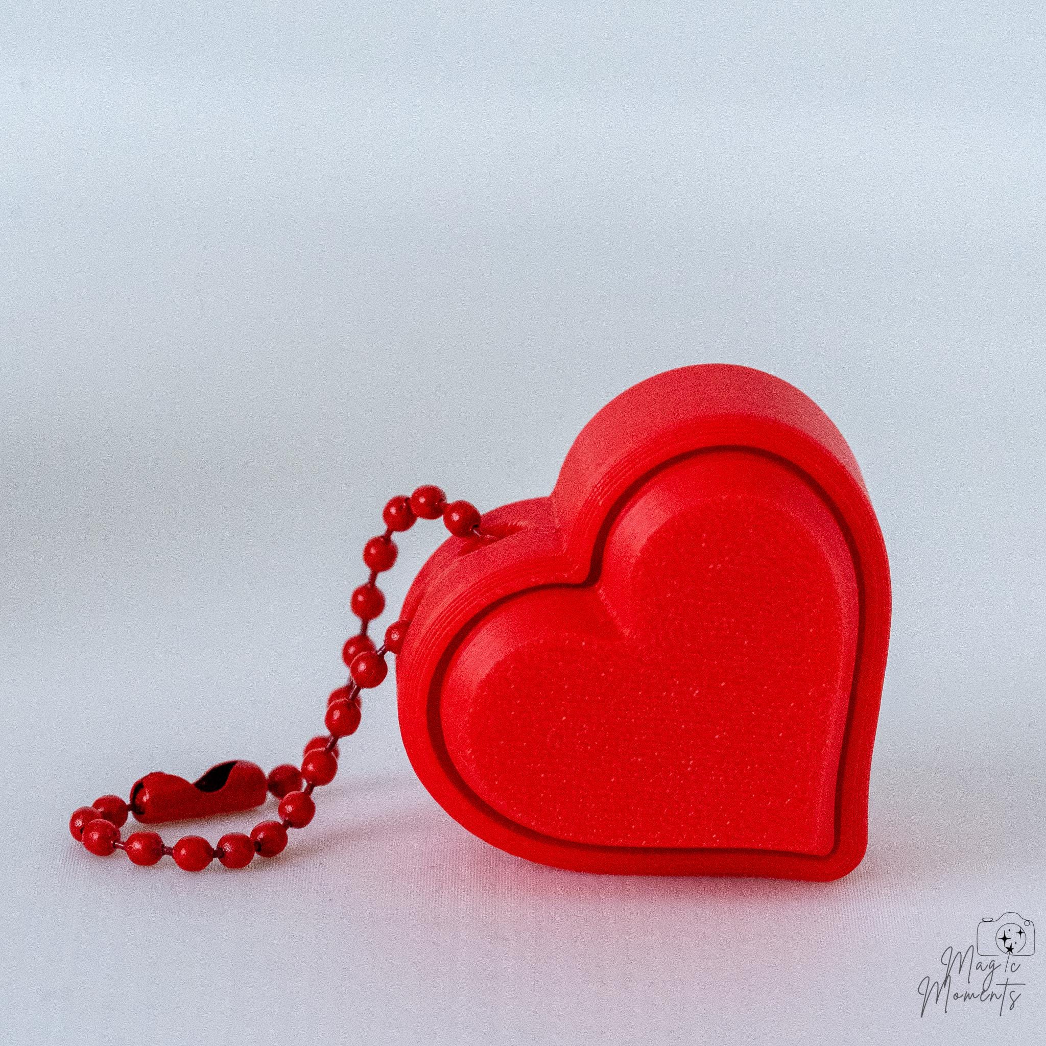 Red heart clicker with hanging loop and minimalist design