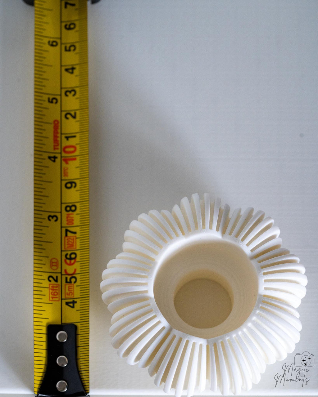 White pumpkin tealight holder viewed from above next to measuring tape for scale
