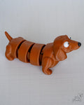 Long dachshund style articulated dog figure with segmented body