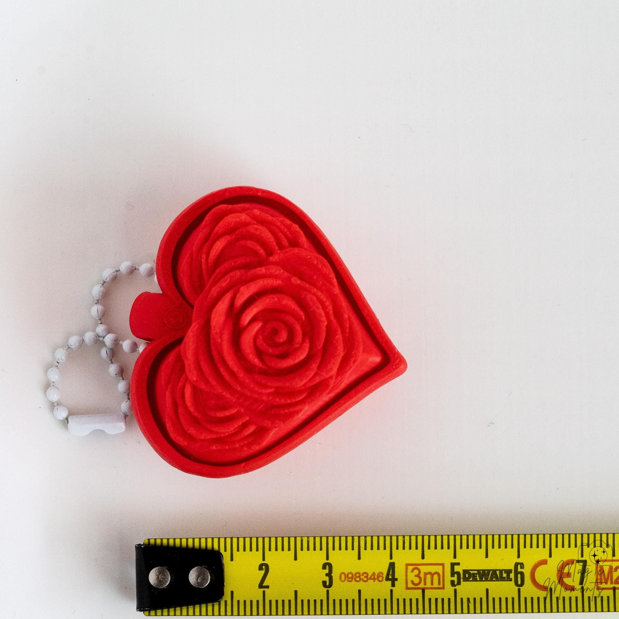 heart keychain next to measuring tape for scale