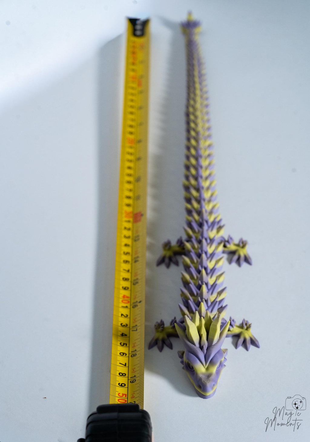 articulated dragon next to measuring tape for scale
