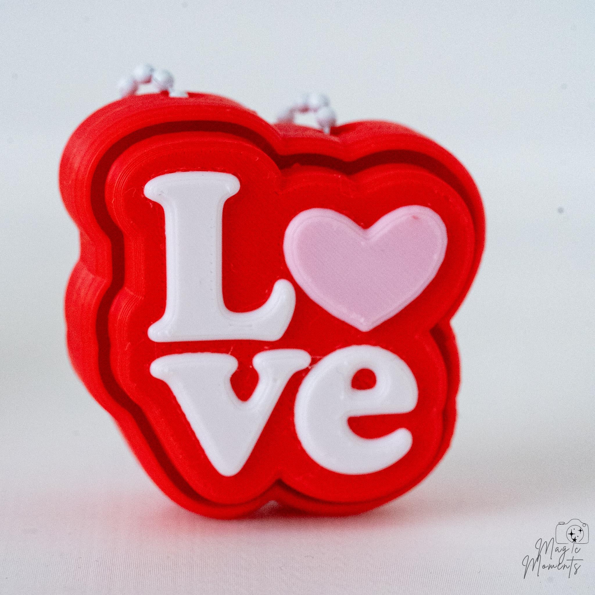Love ornament clicker with hanging loop and heart detail