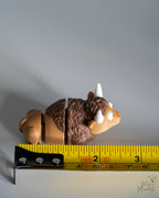 bison figurine next to measuring tape for scale