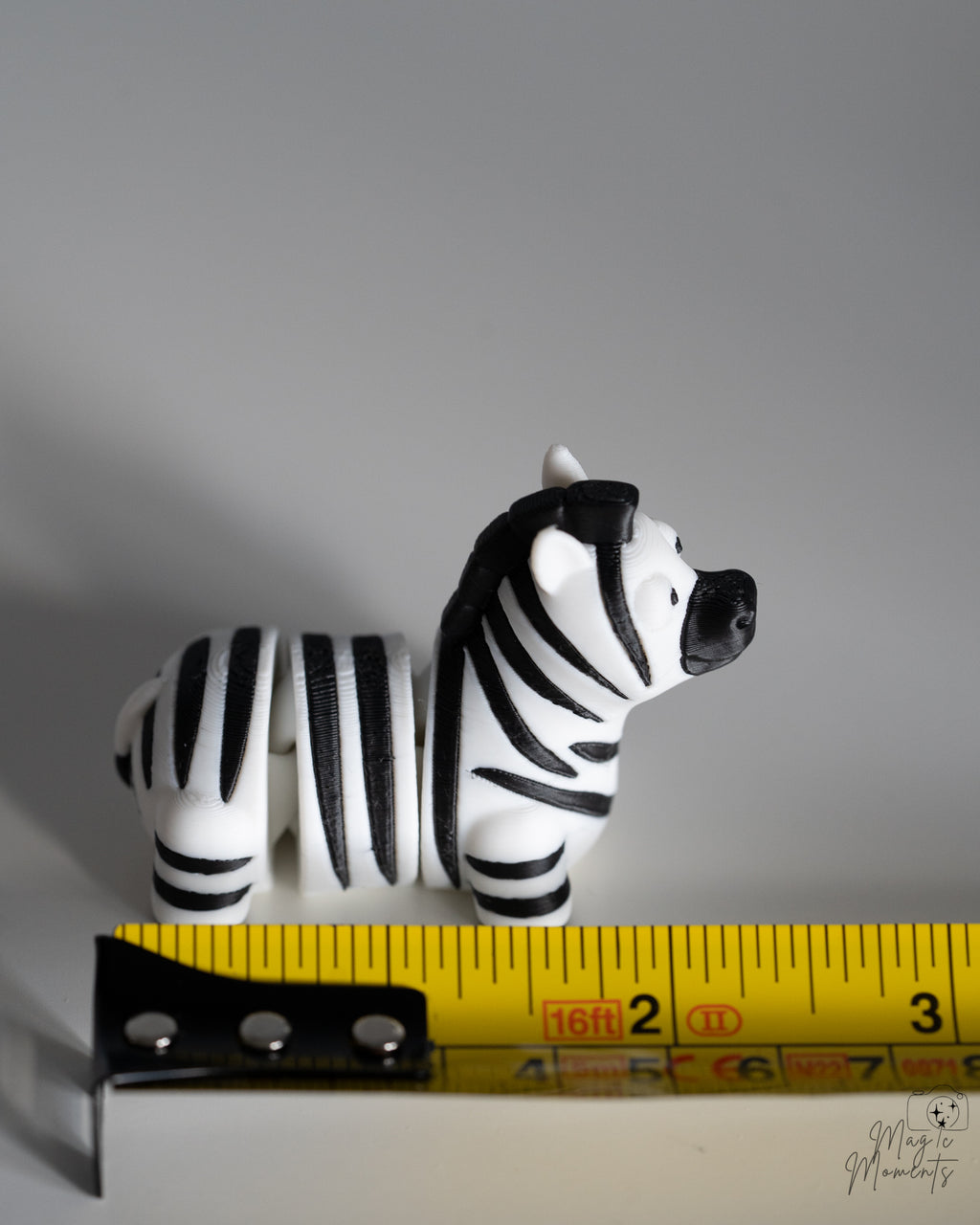 zebra figurine next to measuring tape for scale