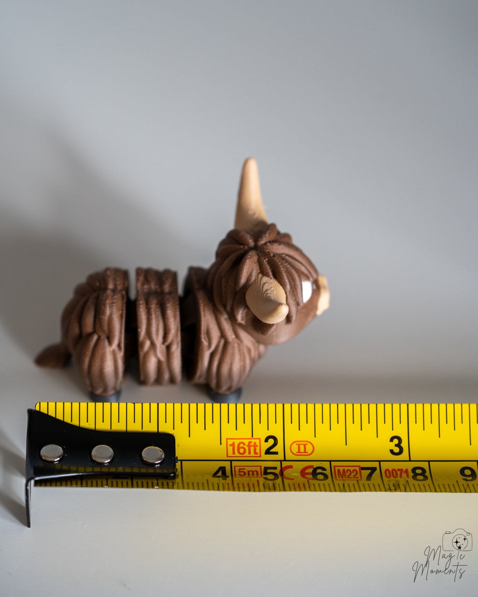 highland cow figure next to measuring tape for scale