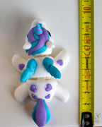Articulated unicorn figure next to measuring tape for scale