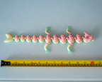 Pastel dragon display figure next to measuring tape for scale