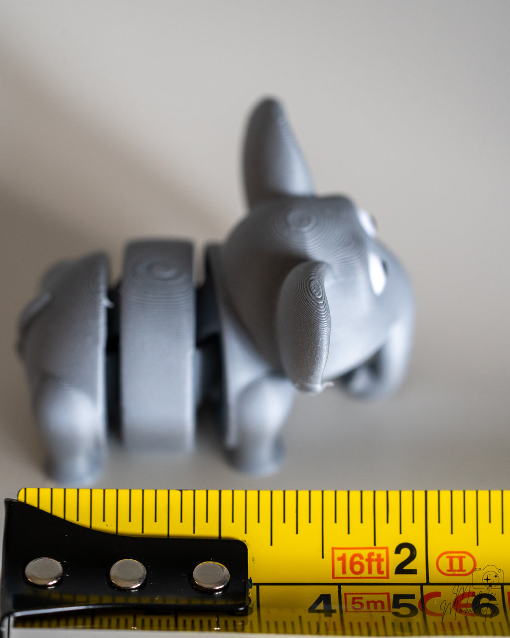 elephant figurine next to measuring tape for scale