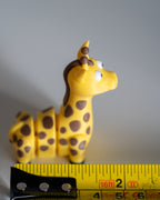 giraffe figurine next to measuring tape for scale