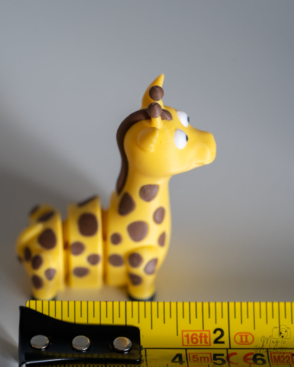 giraffe figurine next to measuring tape for scale