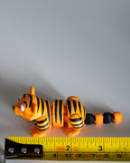 tiger figurine next to measuring tape for scale