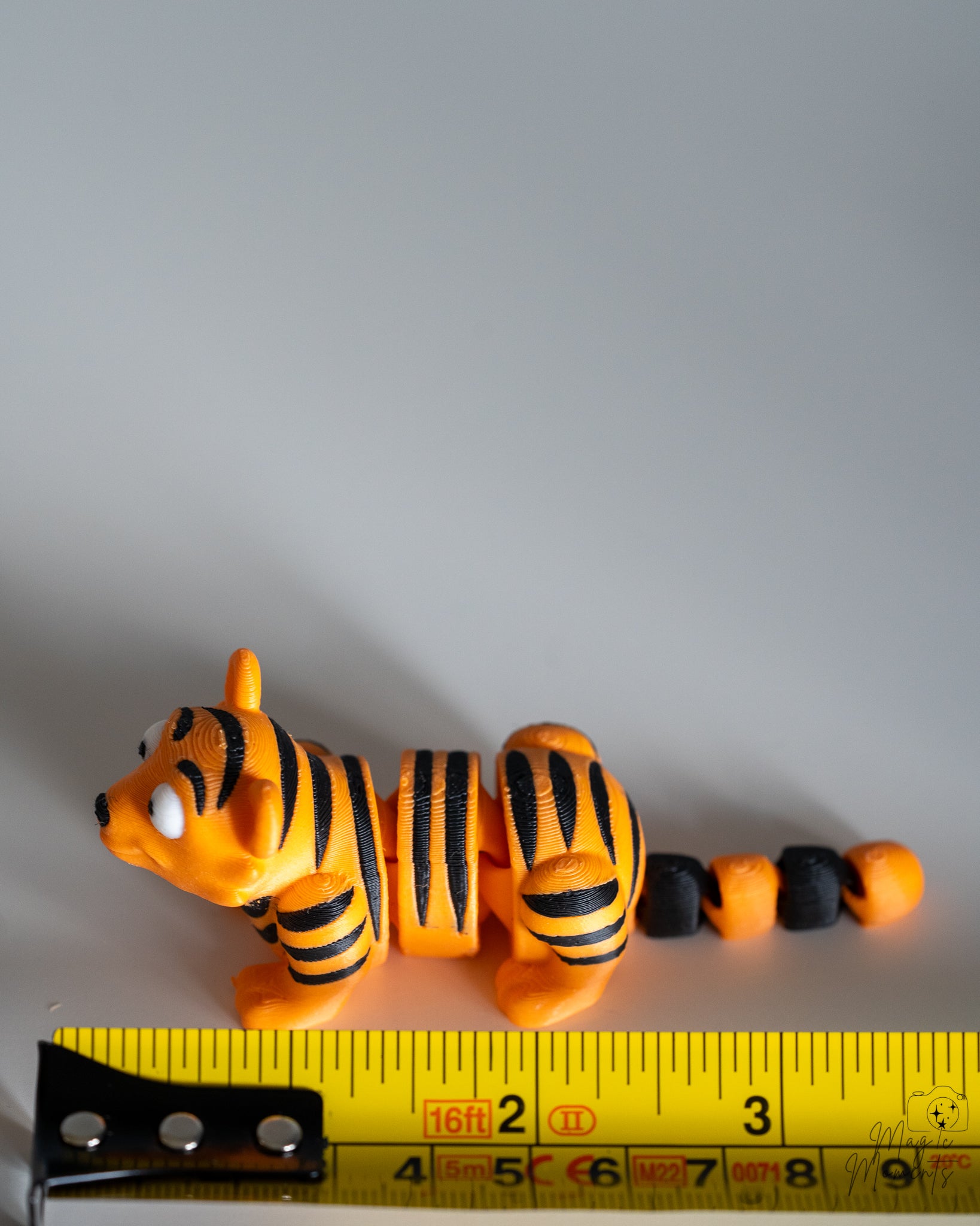 tiger figurine next to measuring tape for scale