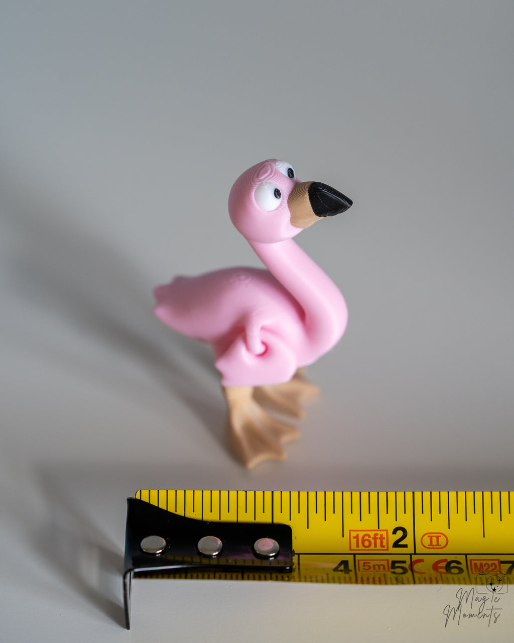 flamingo figurine next to measuring tape for scale