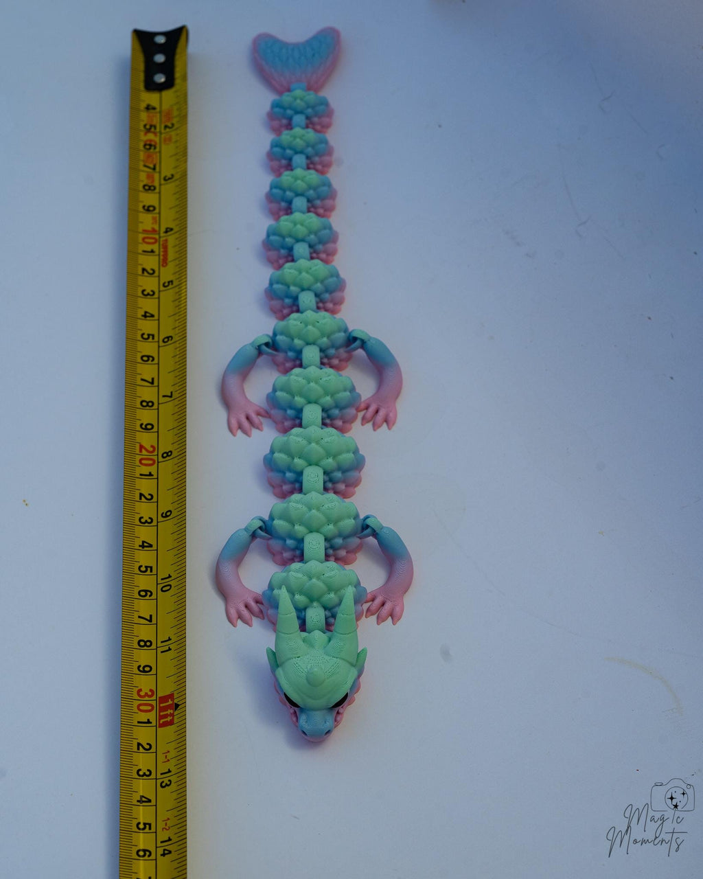 Crystal dragon next to measuring tape for scale