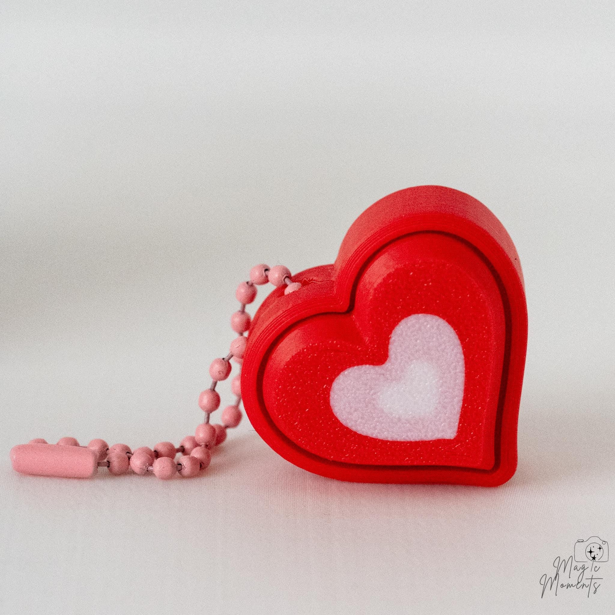 Small heart clicker with pink hanging loop and white heart detail