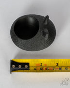 black cat tealight holder next to measuring tape for scale