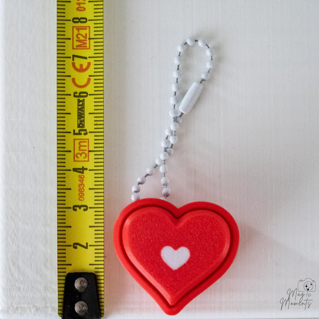 Heart clicker next to measuring tape for scale