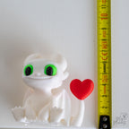 white dragon figurine next to measuring tape for scale