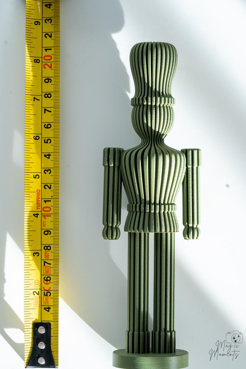 Green nutcracker decoration next to measuring tape for scale