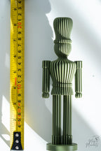 Green nutcracker decoration next to measuring tape for scale