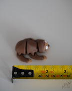 sloth figurine next to measuring tape for scale