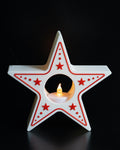 Star-shaped candle holder with red accents on a black background