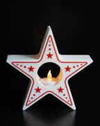 Star-shaped candle holder with red accents on a black background