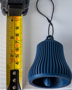 blue christmas bell ornament next to measuring tape for scale