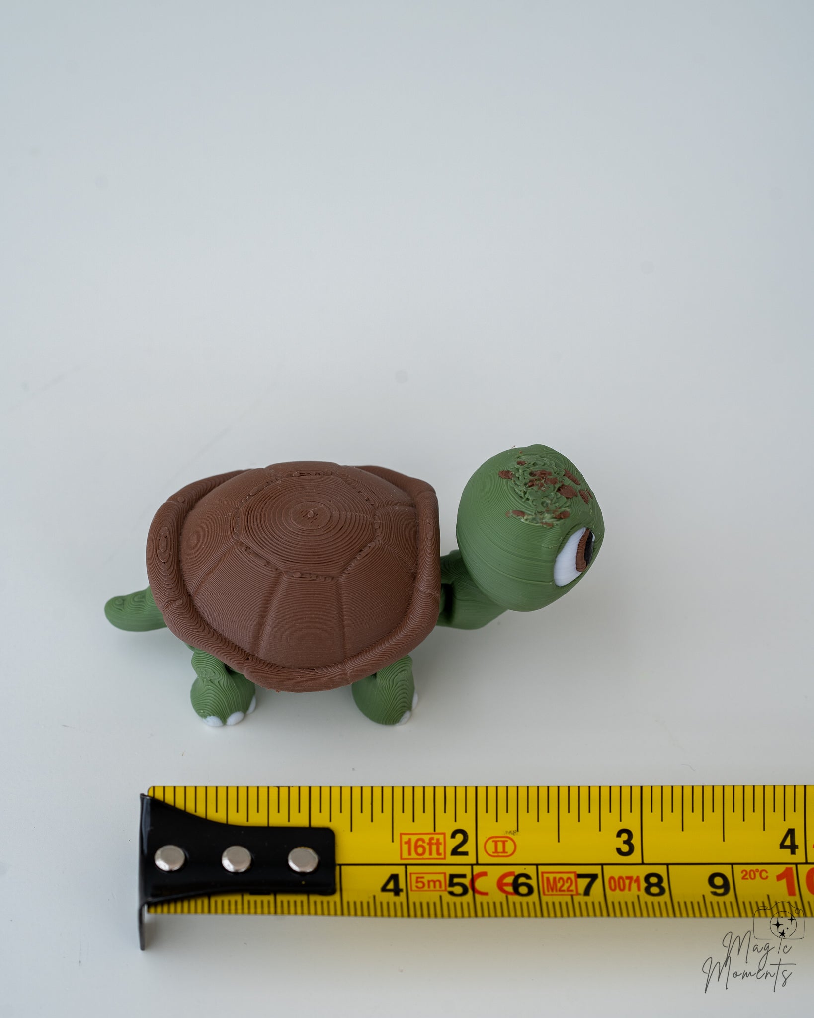 Turtle figure next to measuring tape for scale
