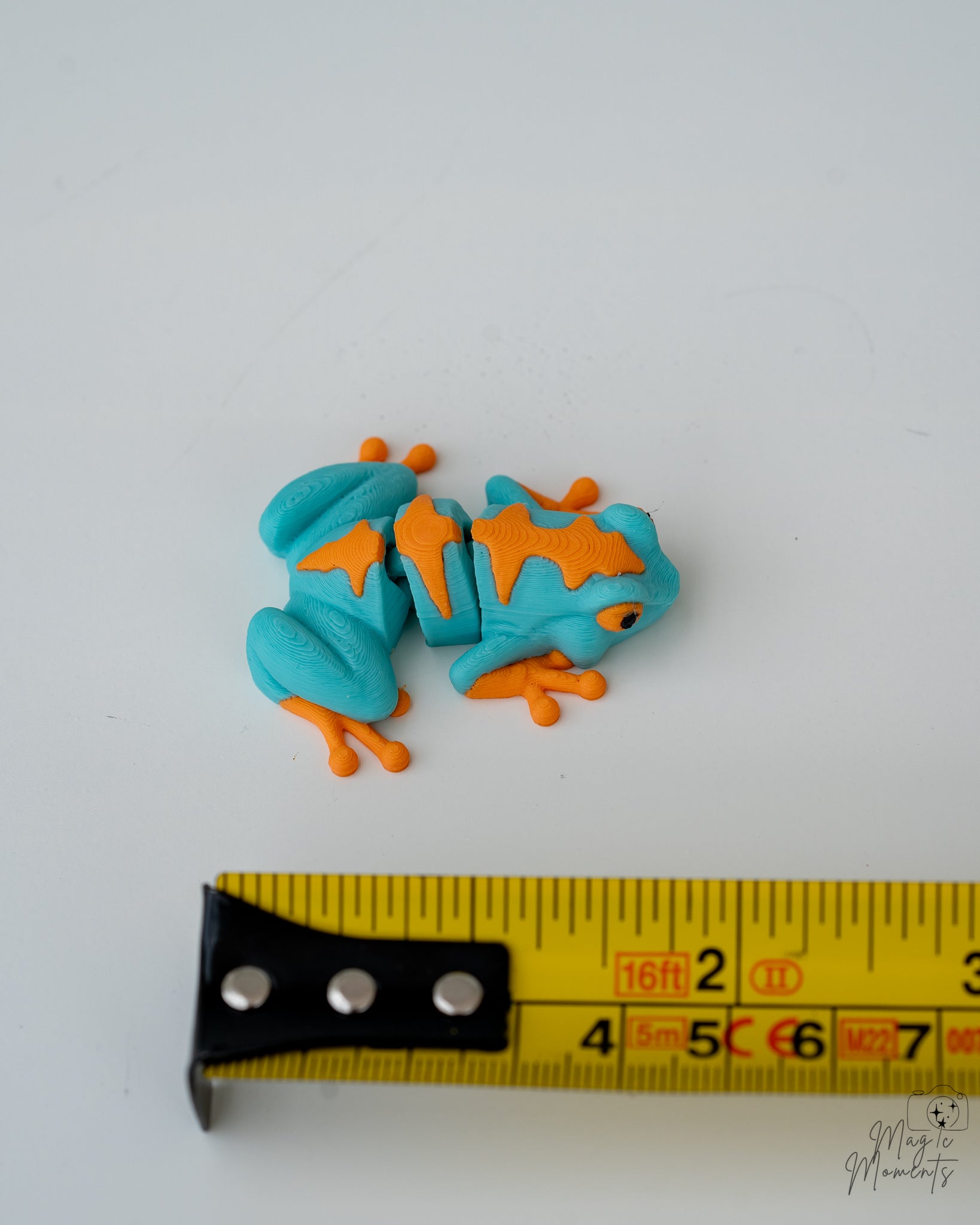 frog figurine next to measuring tape for scale