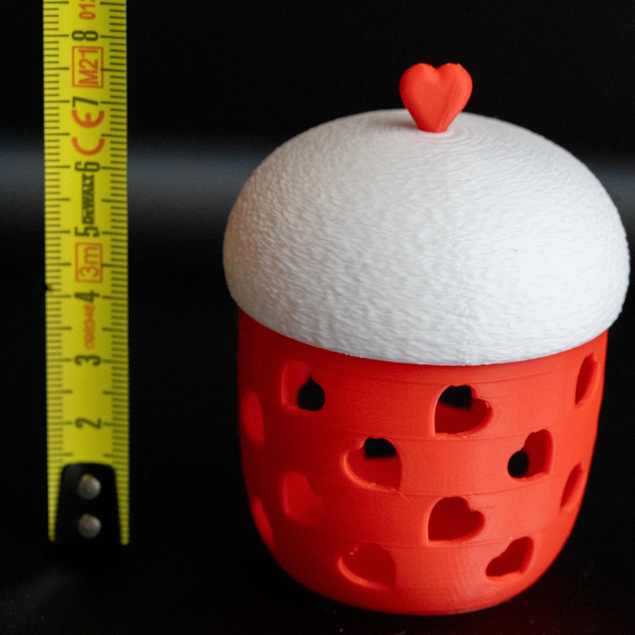 red tealight holder next to measuring tape for scale