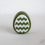 Easter egg clicker with zigzag pattern and green white design