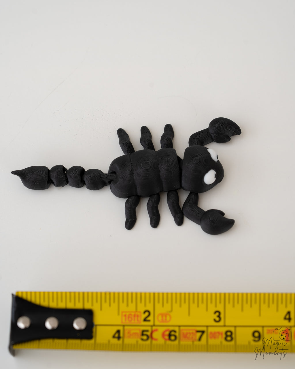 scorpion figurine next to measuring tape for scale