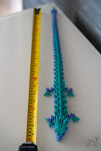 articulated dragon next to measuring tape for scale
