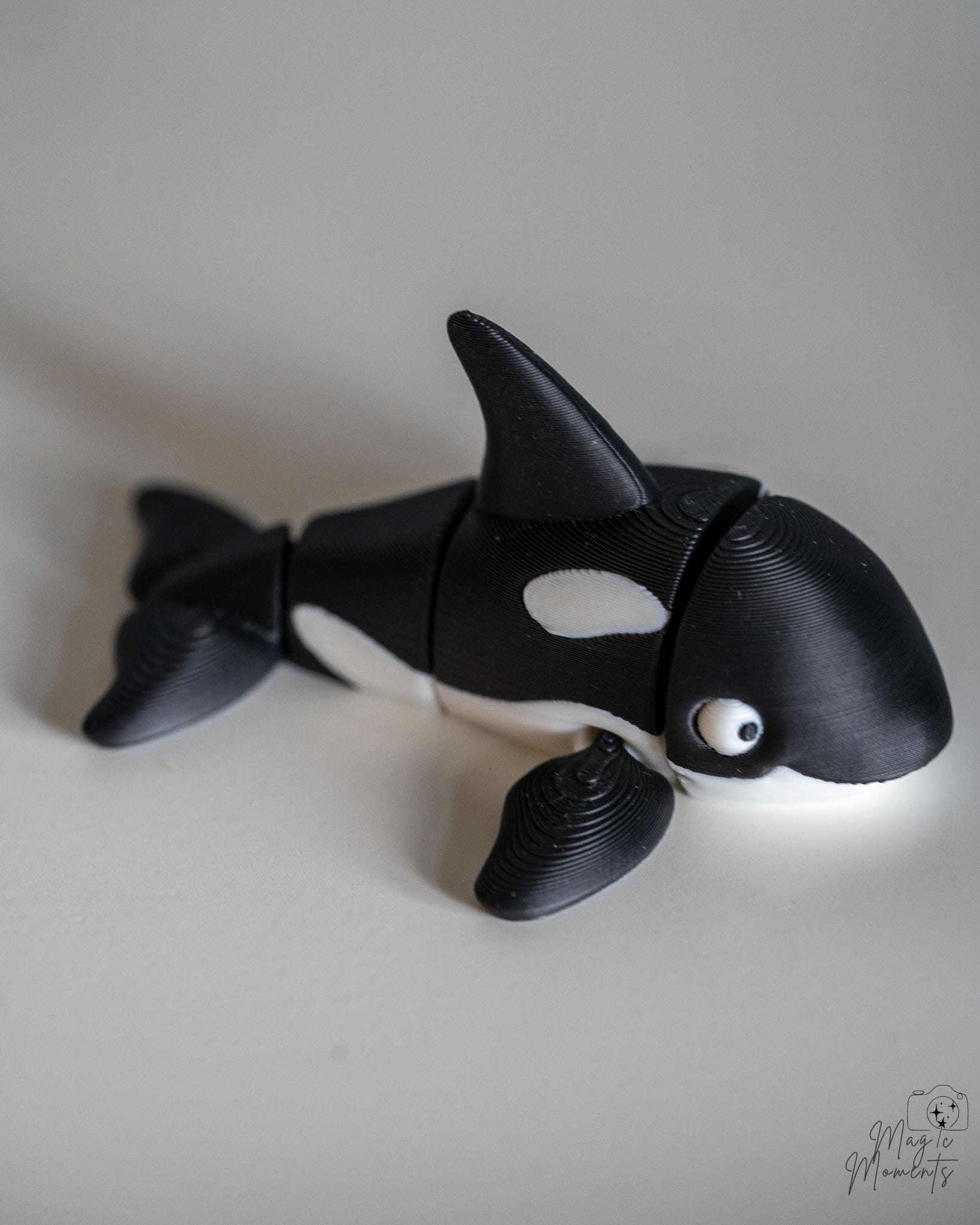 Articulated orca figure with black and white ocean themed design