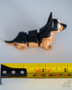 German shepherd dog figure next to measuring tape for scale