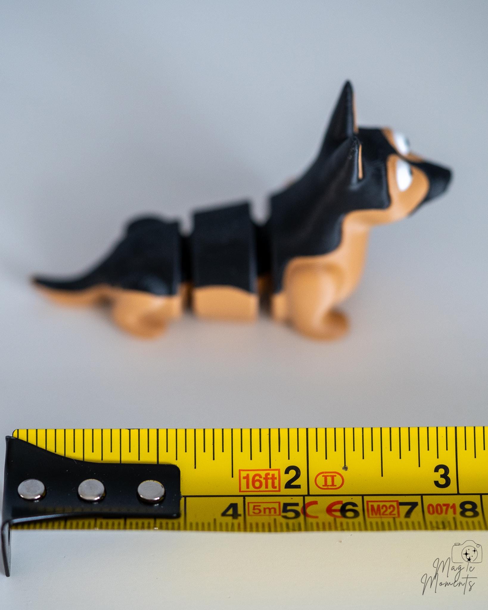 German shepherd dog figure next to measuring tape for scale