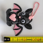 Bat keychain next to measuring tape for scale