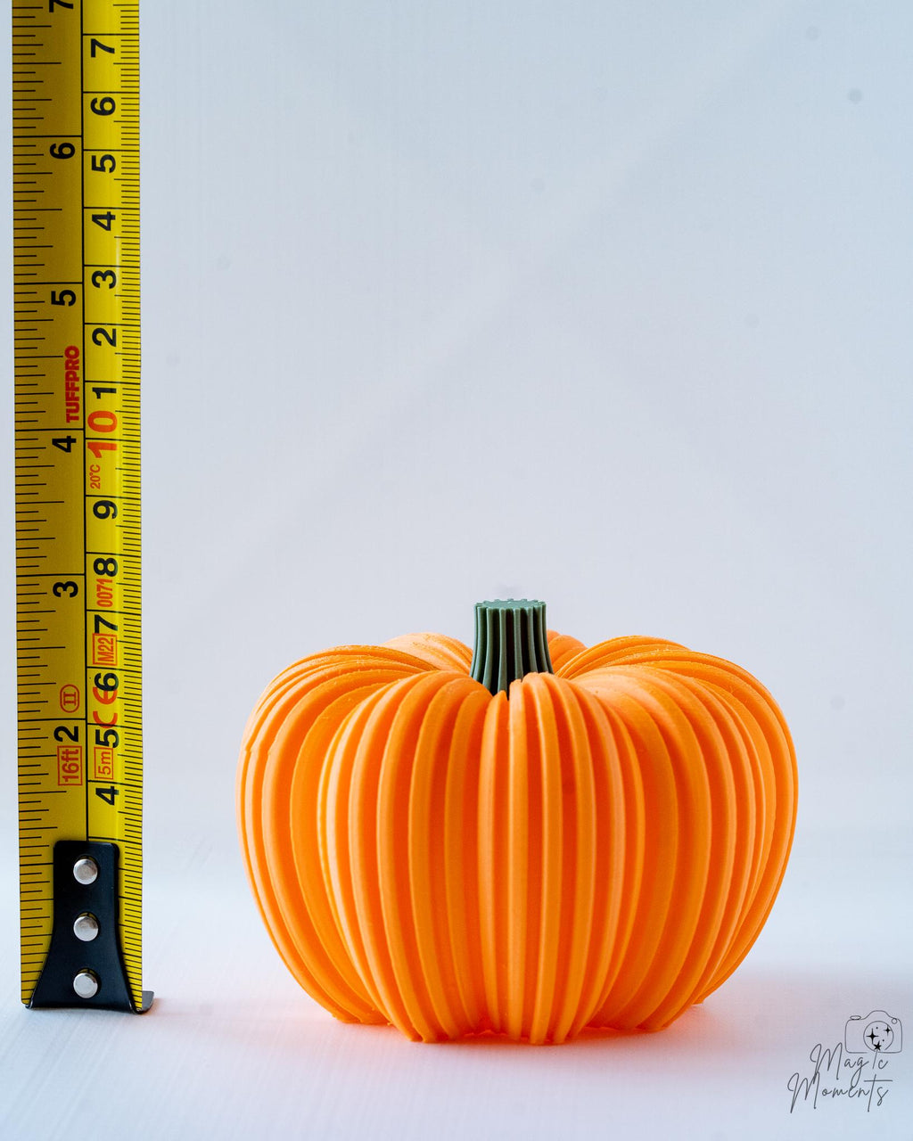 orange ribbed pumpkin next to measuring tape for scale
