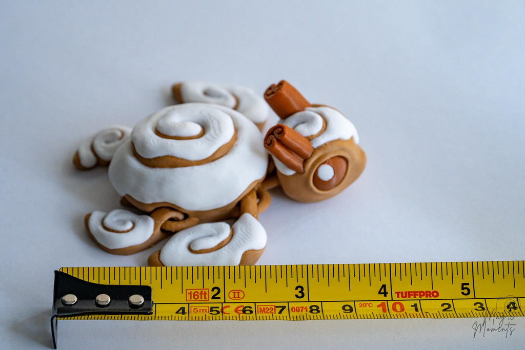 Cute cinnamon turtle figure next to measuring tape for scale