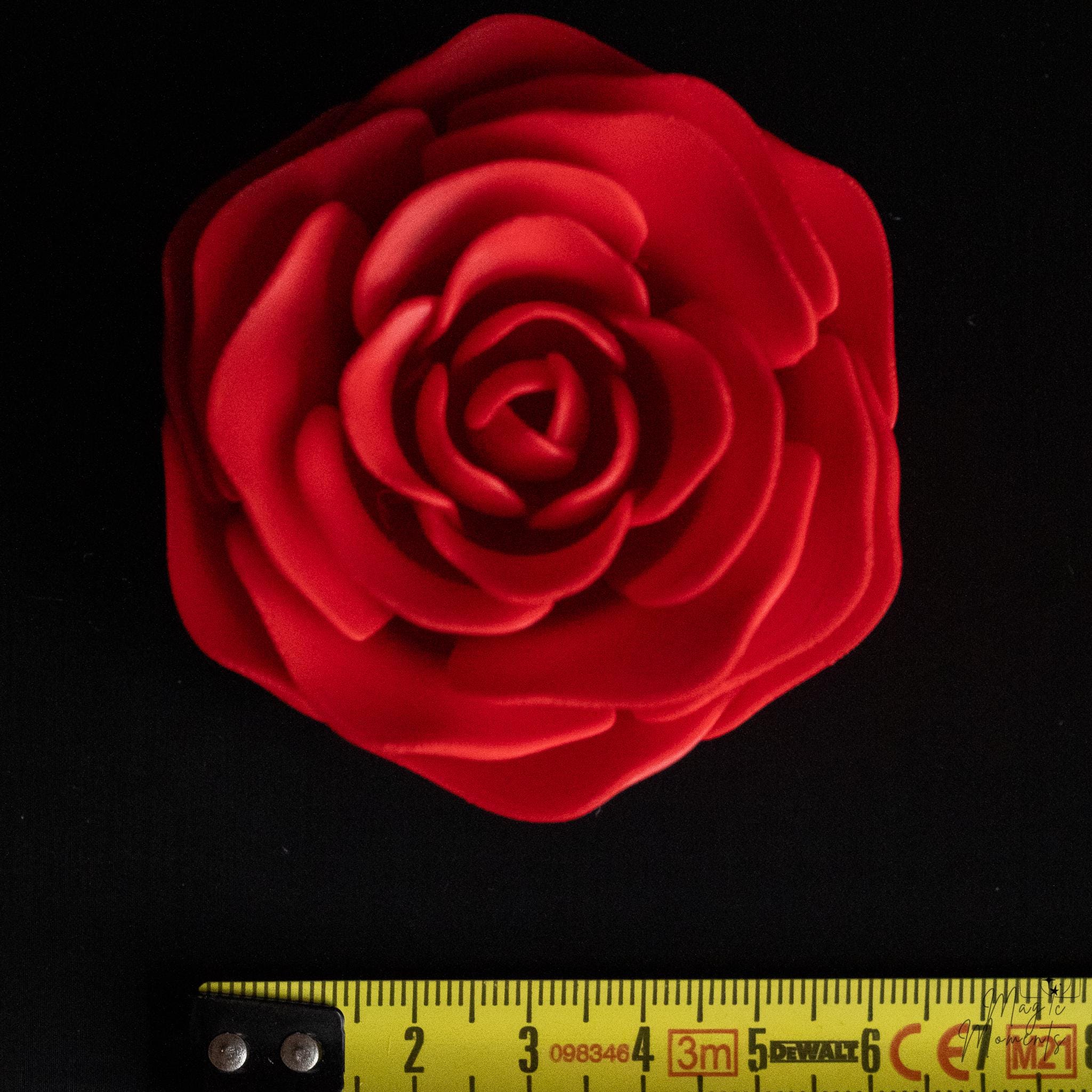 Red rose decoration next to measuring tape for scale