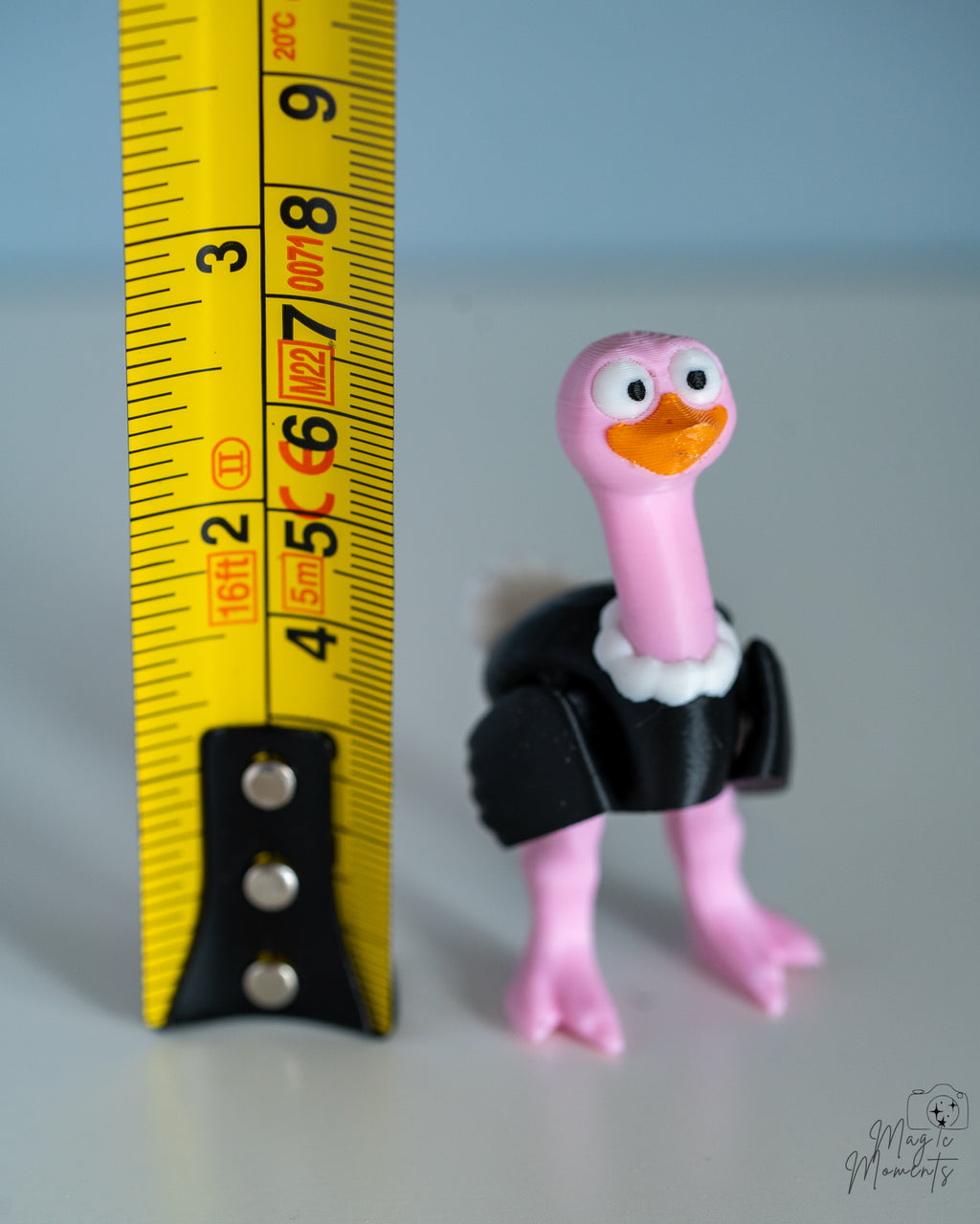ostrich figurine next to a yellow measuring tape for a scale