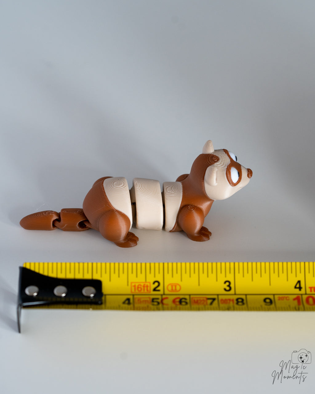 ferret figurine next to measuring tape for scale