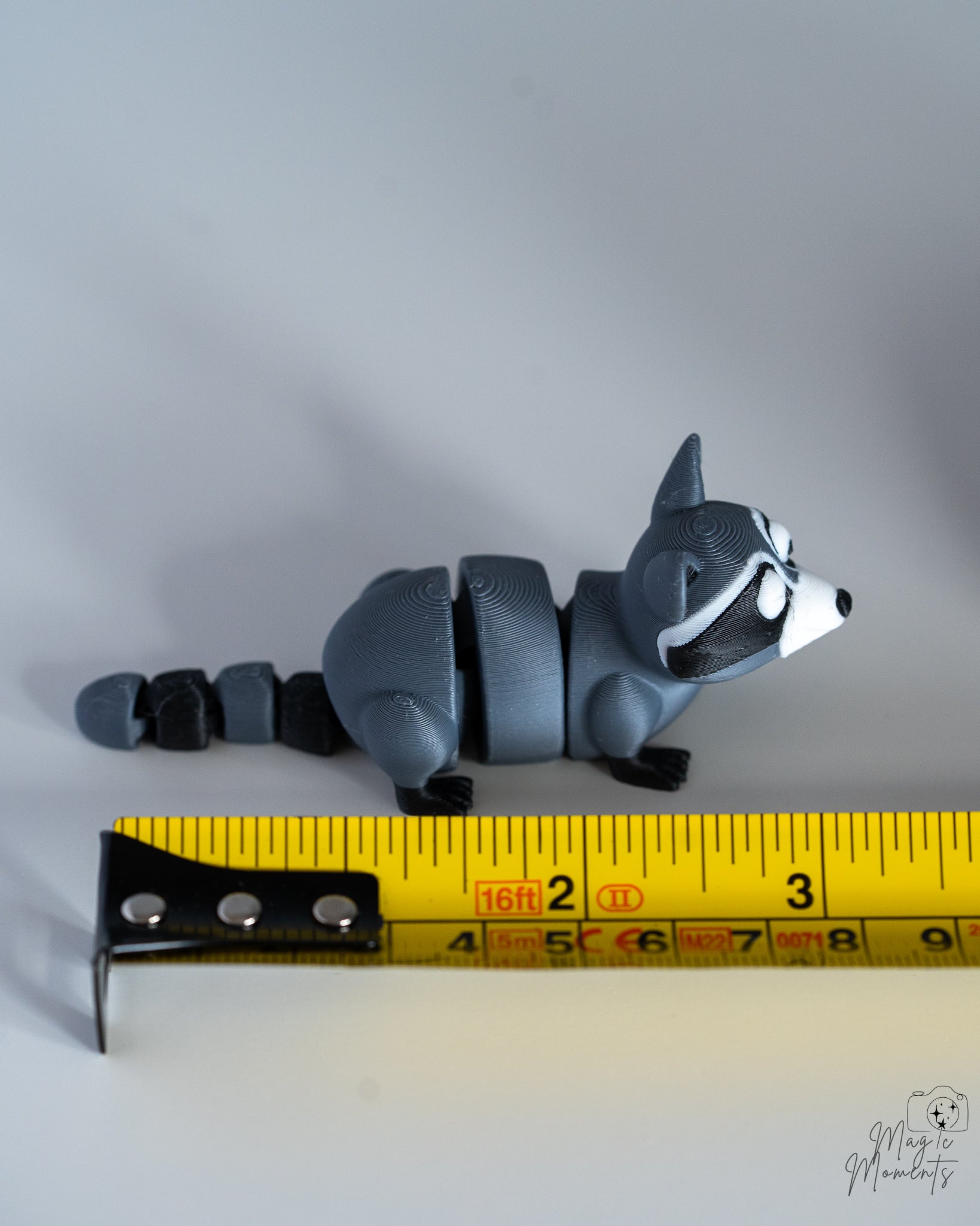 Raccoon figure next to measuring tape for scale