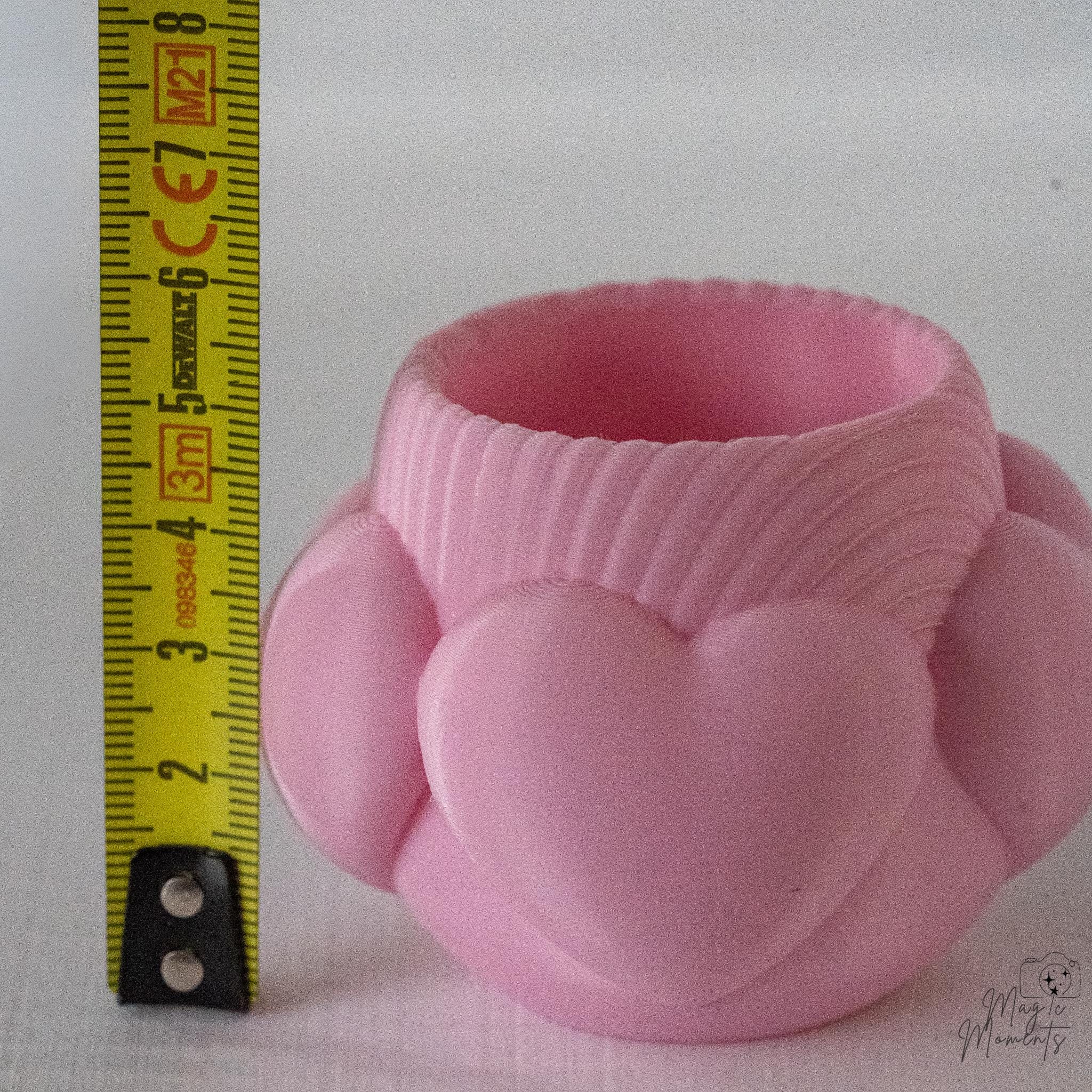 Pink heart tealight holder next to measuring tape for scale