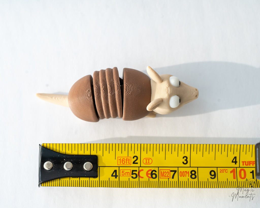 armadillo figurine next to measuring tape for scale