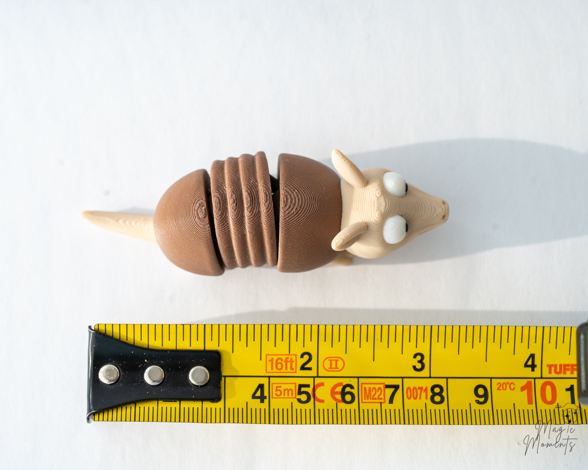 armadillo figurine next to measuring tape for scale